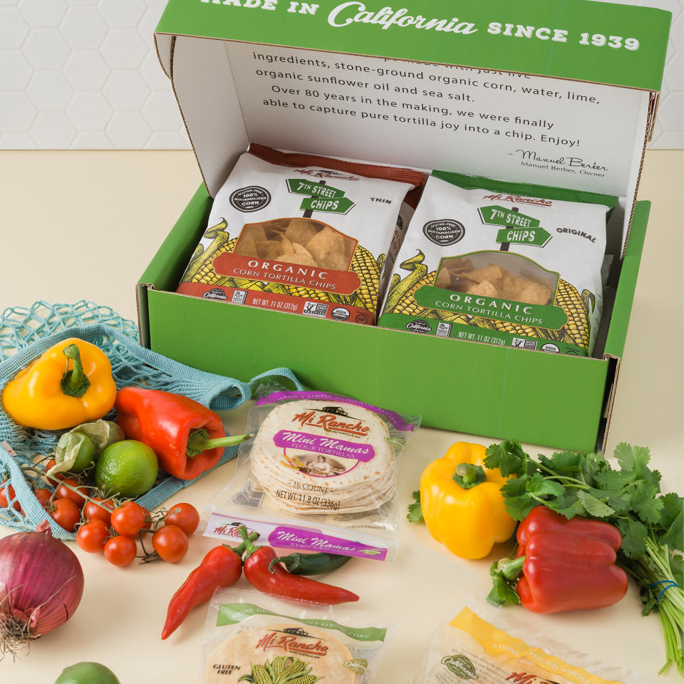 Variety of Mi Rancho products layed out with peppers and herbs on table